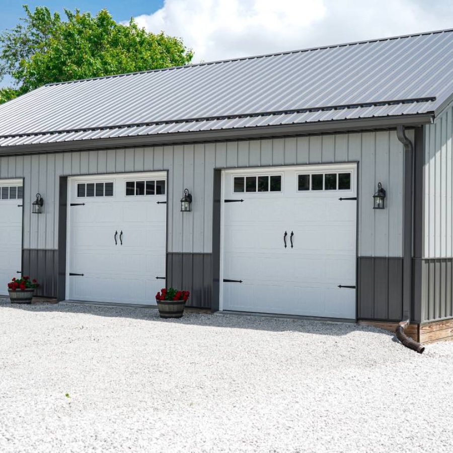 3 white overhead doors on large outd